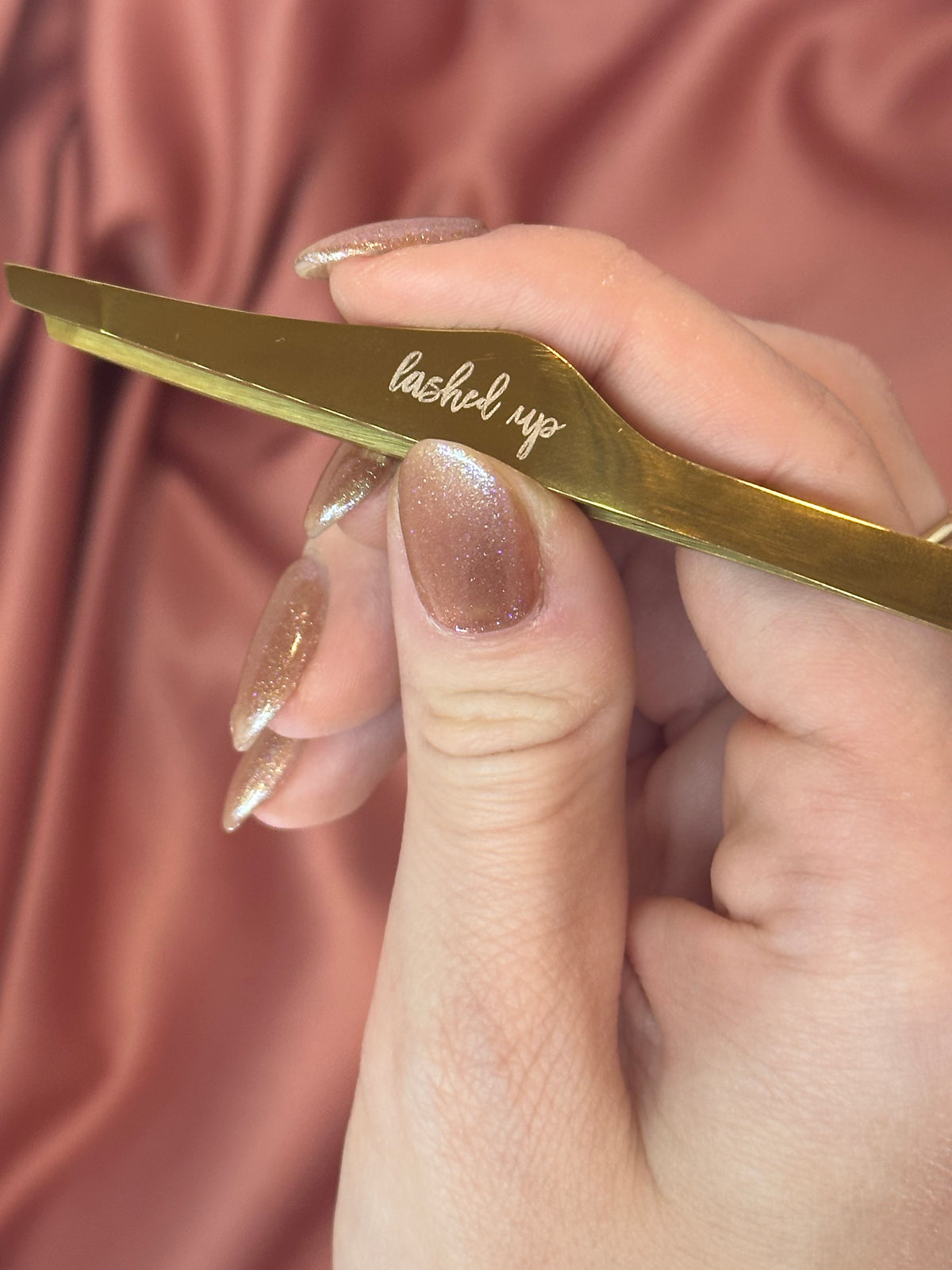 Gold brow tweezers engraved with lashed up